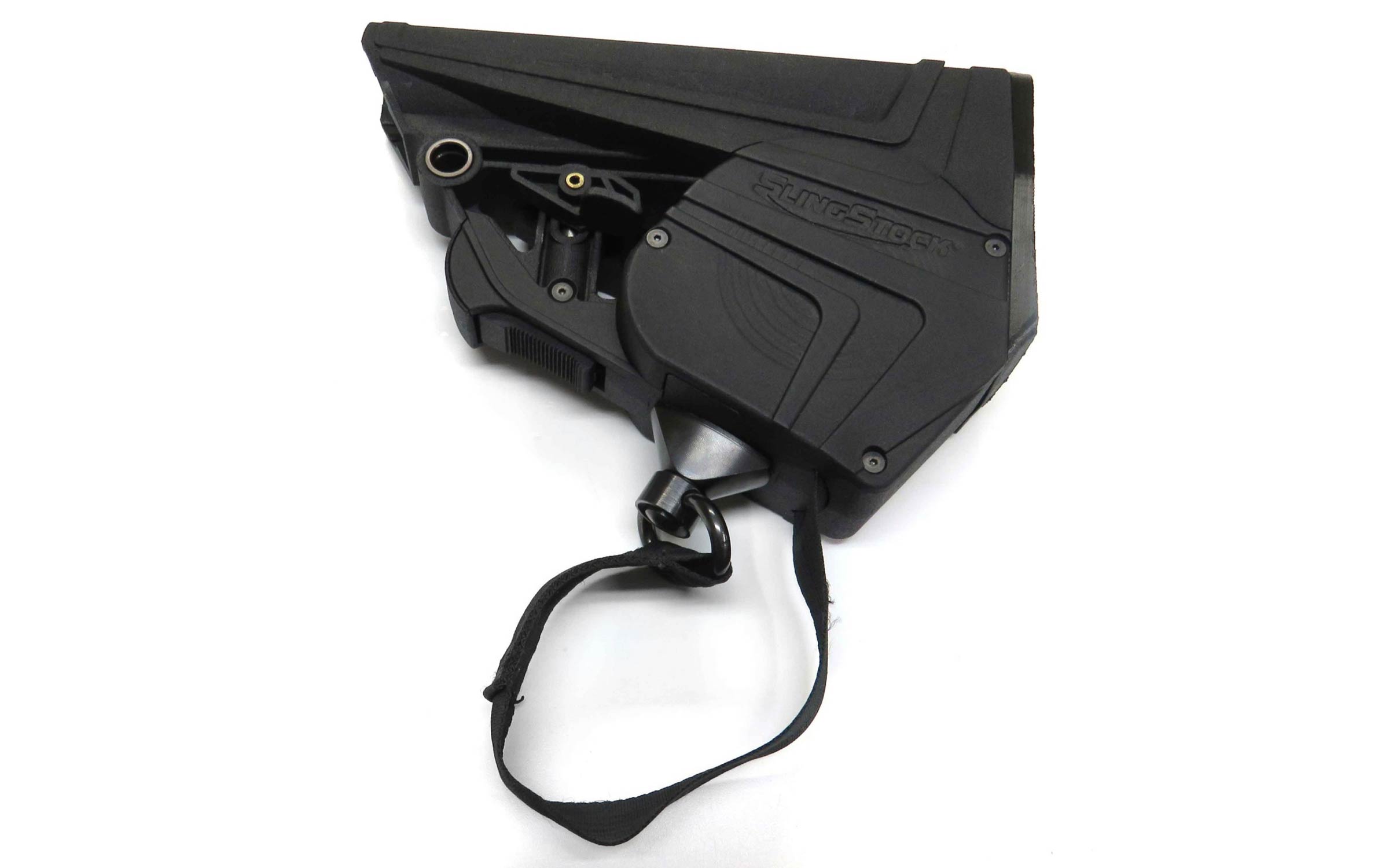 Black adjustable rifle stock with an attached strap, viewed from above on a white background. The stock has textured surfaces and visible screws.