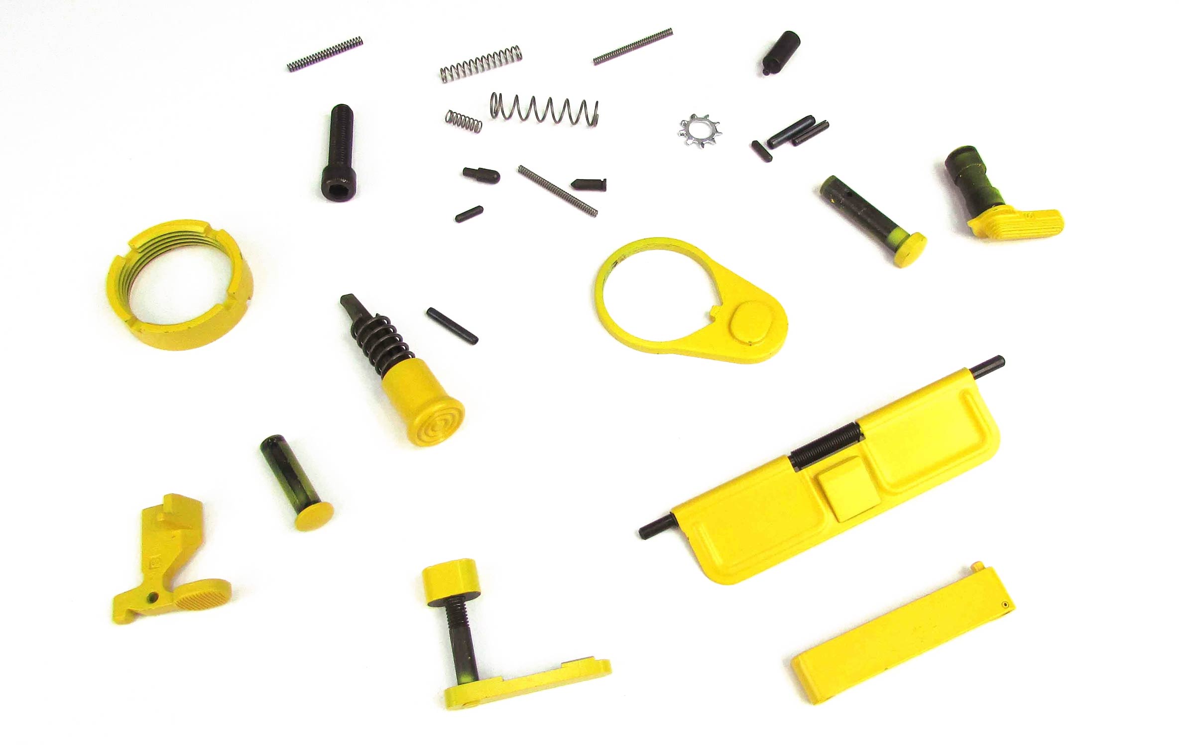 Assorted yellow and black mechanical parts and small metal springs scattered on a white background, appearing to be components of a device or tool.