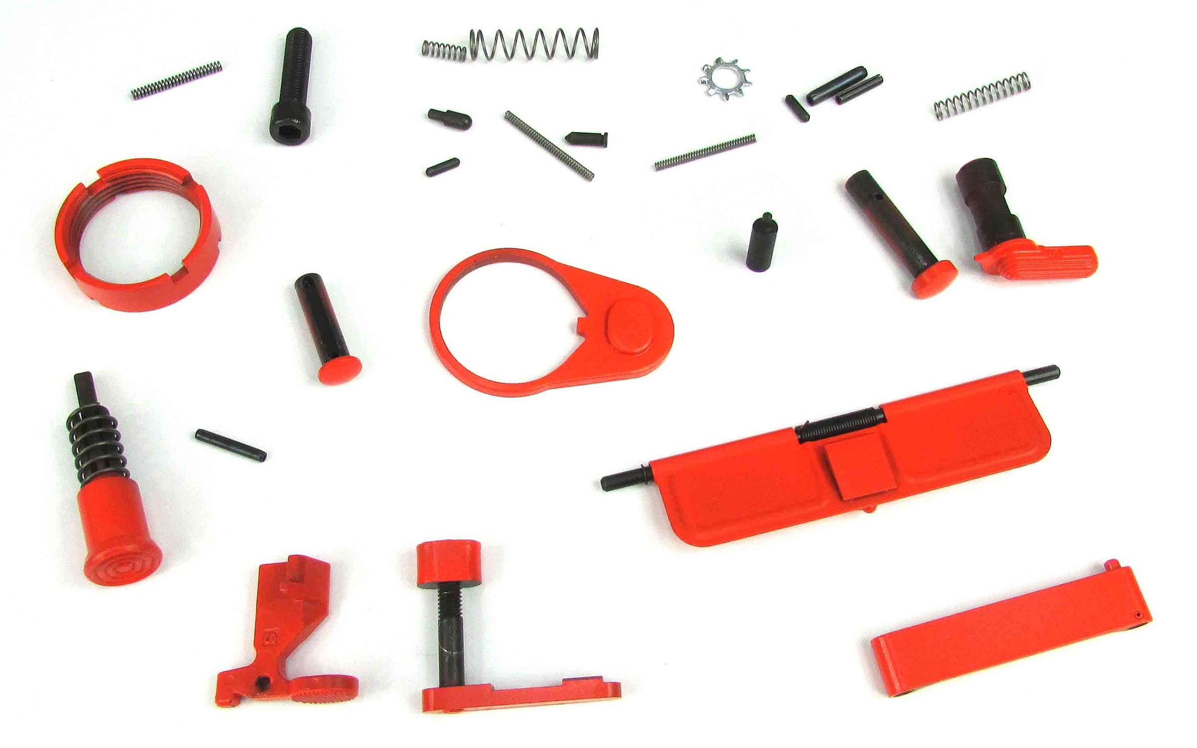 Several red and black small firearm parts, springs, and pins are spread out on a white surface, arranged in a loose, organized manner.