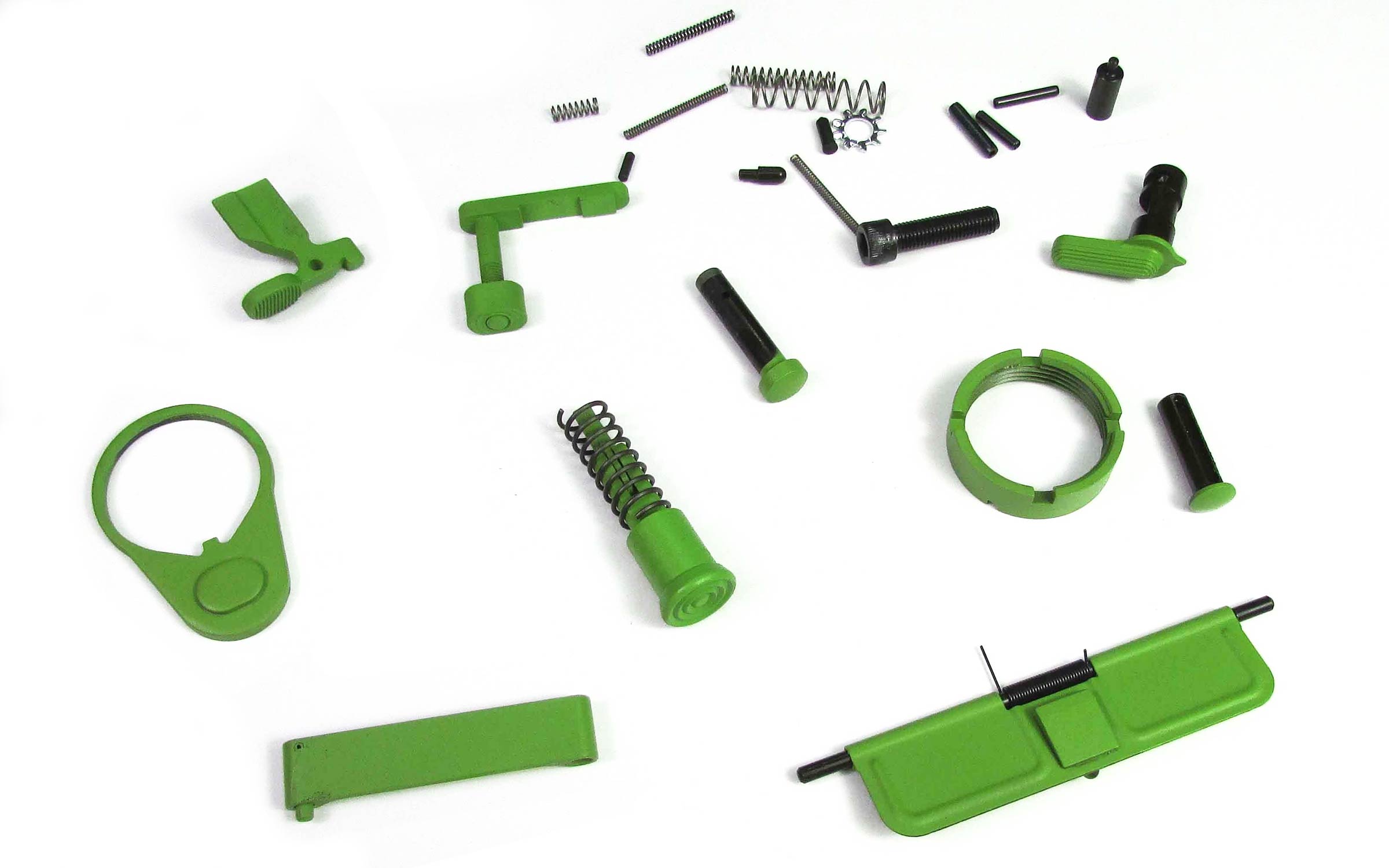 Assorted small green metal firearm parts are laid out on a white background, including springs, pins, levers, and covers, all neatly spaced apart.